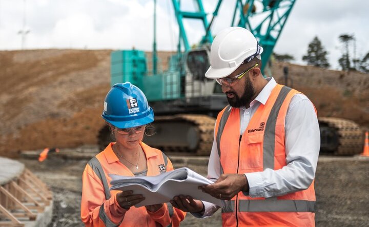 Photo of two of our team on a construction site talking about an infrastructure project